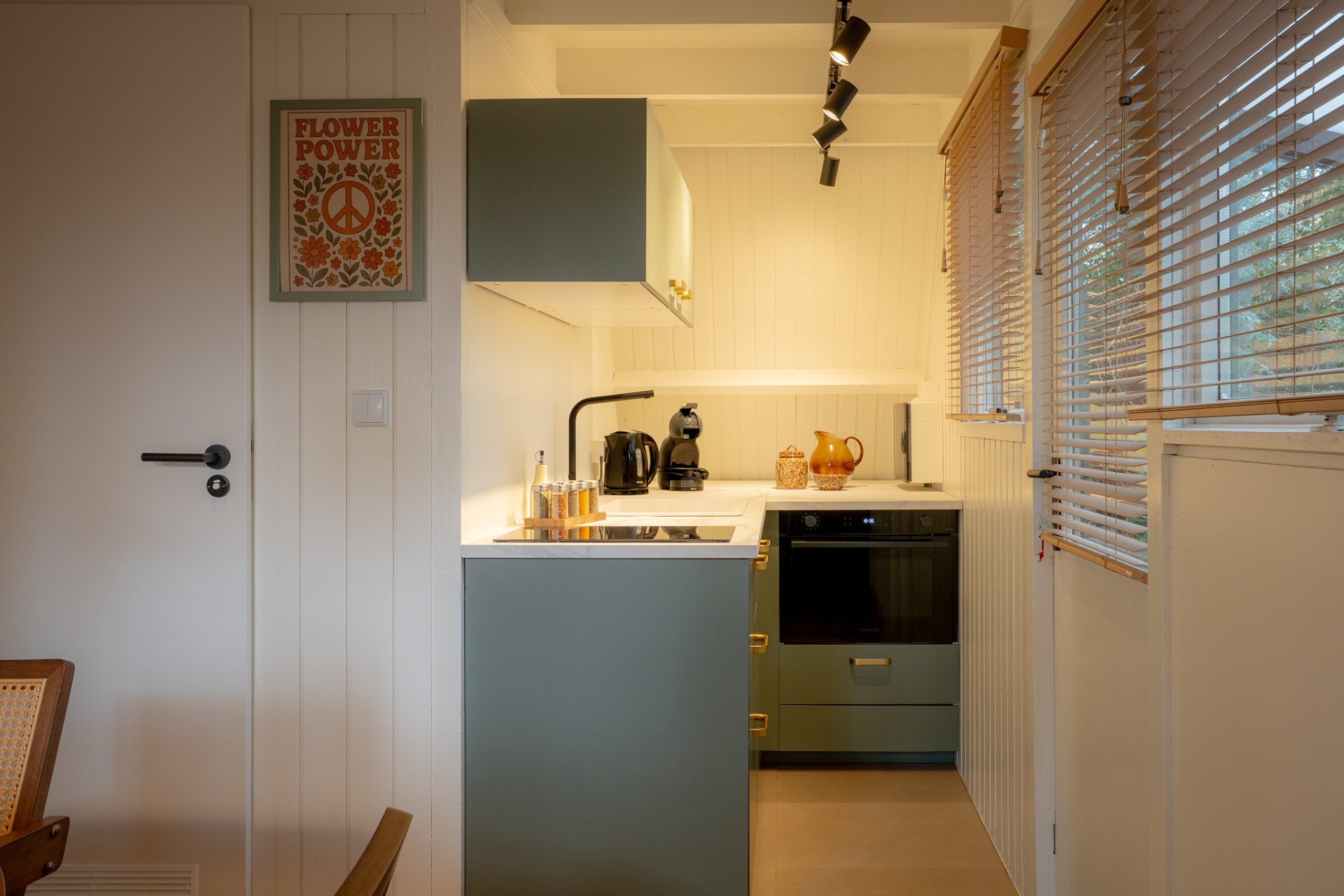 Keuken met groene kastdeuren en raam