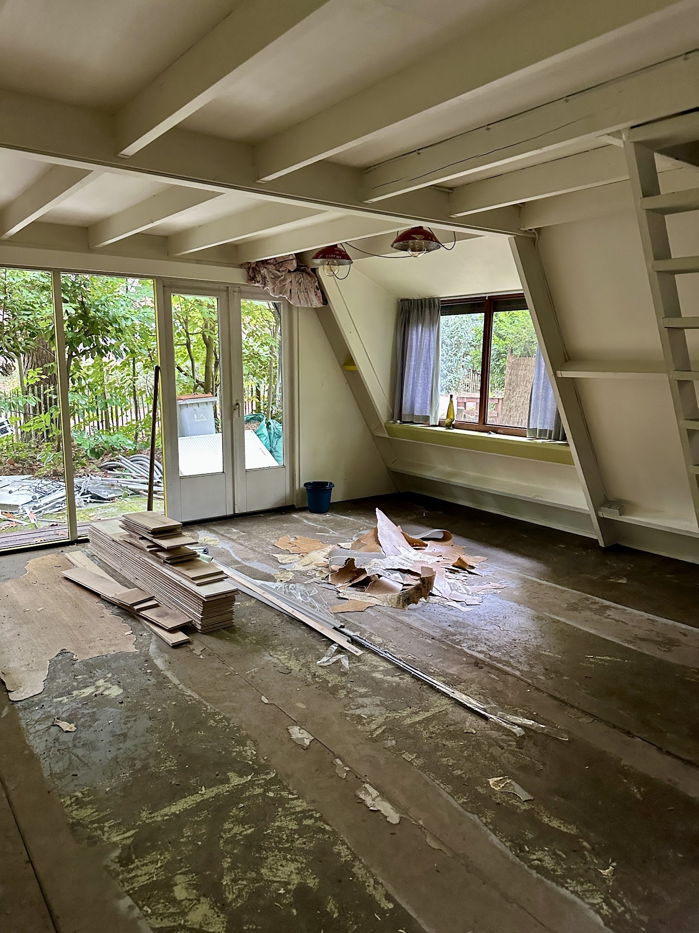 Werkfase: binnenruimte met los materiaal op de vloer en tuindeuren