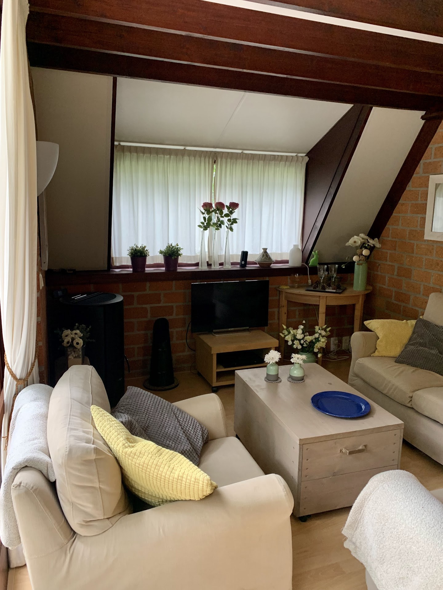 Interieur met bank, donkere plafondbalken en raam