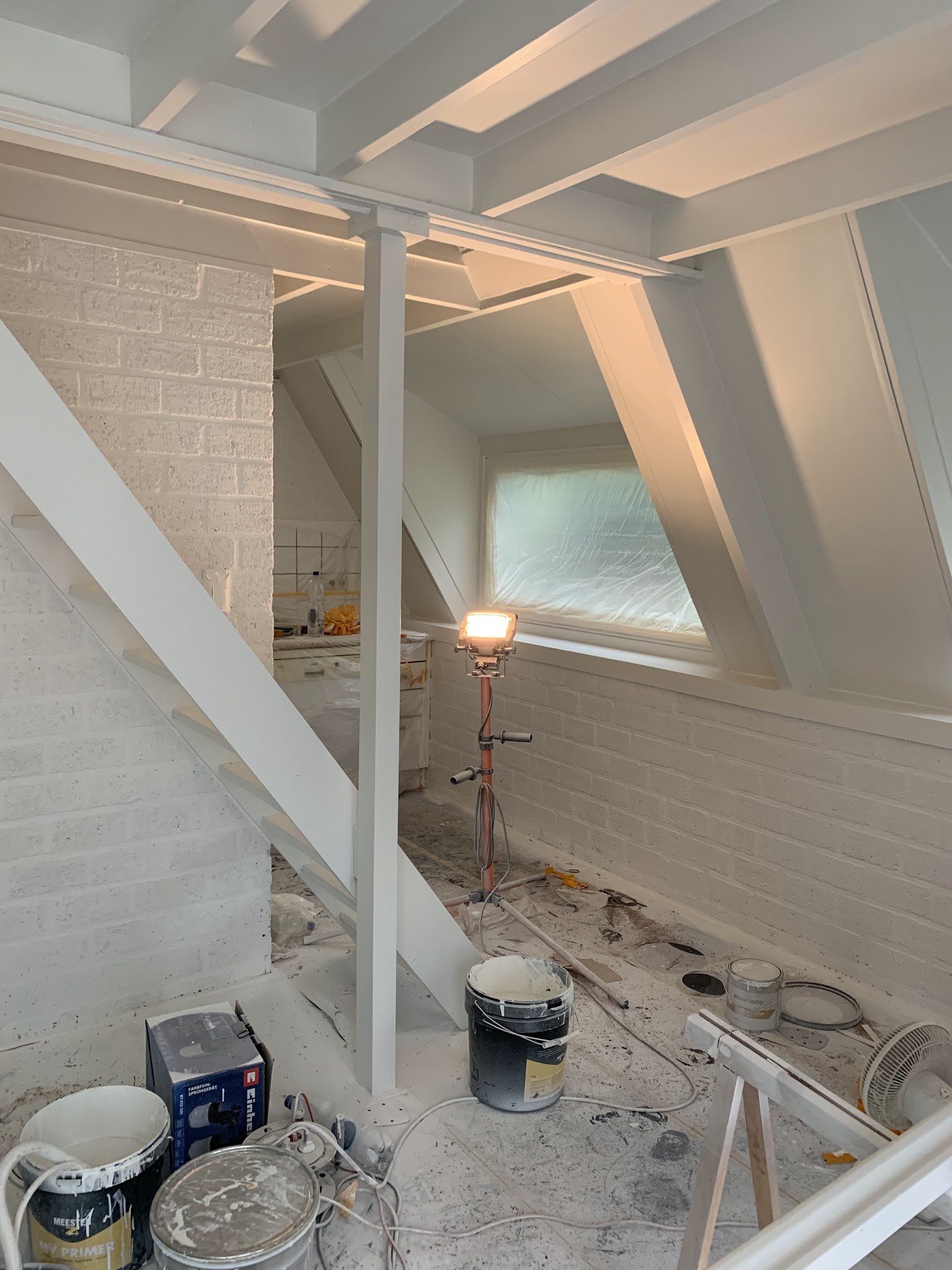 Werkfase: binnenruimte met bouwmateriaal op de vloer en tijdelijke verlichting